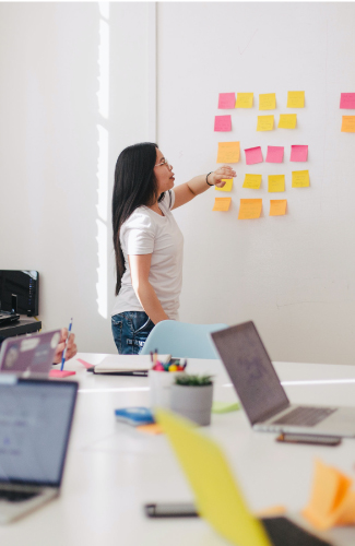 A group of people discussing post-it notes in a meeting.
